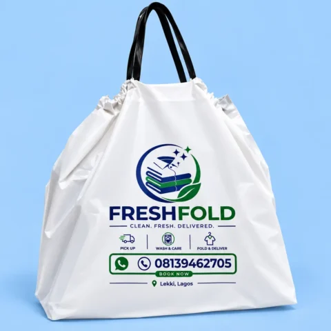 Drawstring Bag Printing White custom plastic laundry bag with black loop handles and printed navy and green laundry branding on a light blue background.